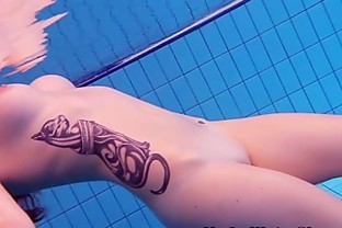Redheaded cutie swimming nude in the pool