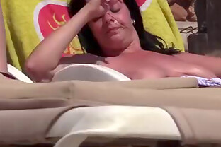 Topless beach voyeur video with a sexy brunette