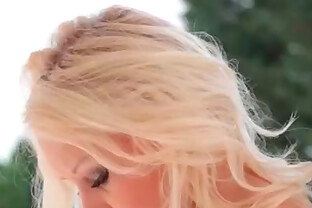 Blonde teen in a sexy striptease outdoors